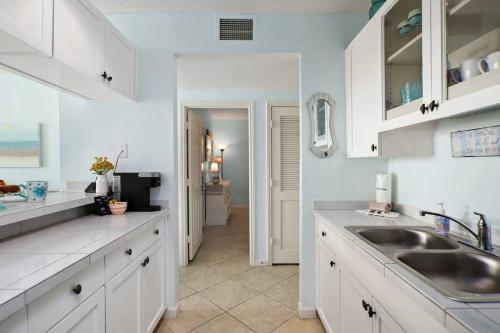 加尔维斯敦Beachfront Sunrise 的厨房配有白色橱柜和水槽