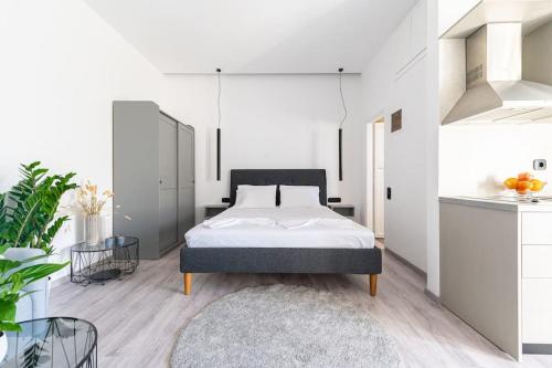 海若克利欧Elegant Fully Equipped Apartment near City Centre的一间白色卧室,配有床和厨房