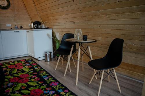 皮亚特拉-尼亚姆茨Casuta Mea的厨房配有桌子、两把椅子和冰箱