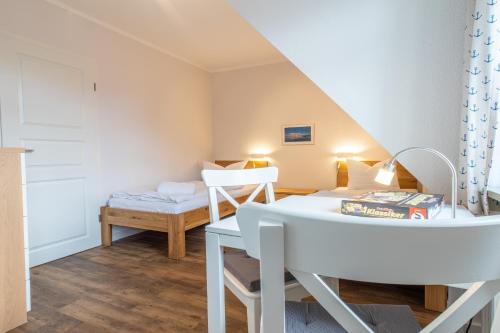 欧巴德伍斯图Ferienhaussiedlung Strandperlen Buchenhof 2b (Typ VI)的小房间设有白色桌子和一张床