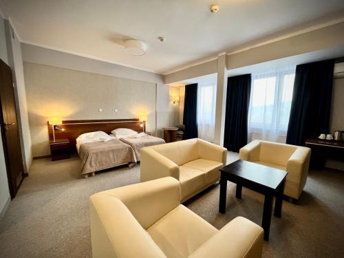 别尔斯克-比亚拉Hotel Szyndzielnia的酒店客房配有一张床、一张沙发和椅子。