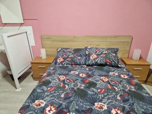 巴利亚多利德PENSION ZEUS的一间卧室配有一张带花卉棉被的床