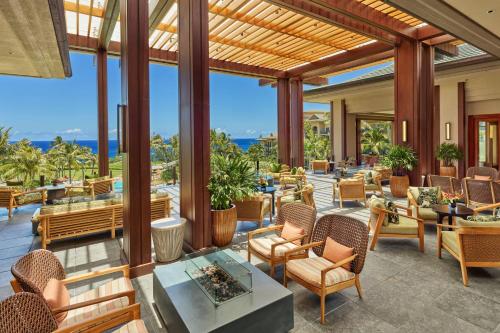 拉海纳The Ritz-Carlton Maui, Kapalua的一个带桌椅的户外庭院,享有海景