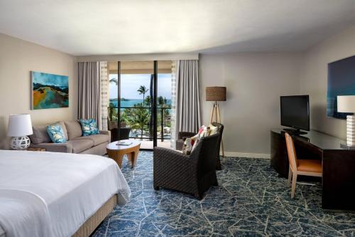 瓦克拉威可洛亚海滩万豪Spa度假酒店的酒店客房设有一张特大号床和一间客厅。