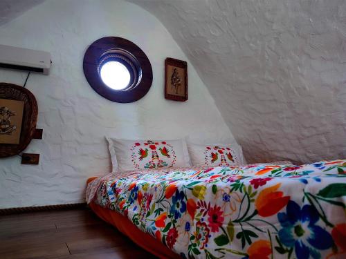 波卢巴库苏斯Căsuțele de sub Șipote的一间卧室配有一张带花卉床罩的床和窗户。