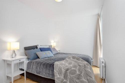 奥斯陆Tjuvholmen - ved Aker Brygge的一间卧室配有一张带床头柜的床和一张四柱床。