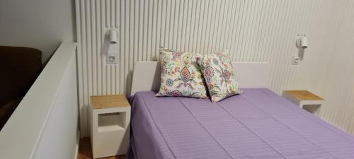 维拉摩拉Victoria Studio的一间小卧室,配有一张带枕头的紫色床