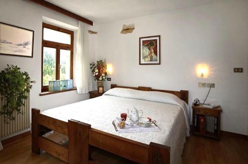 福尔尼阿沃尔特里Albergo Piani di Luzza的一间卧室配有一张床,上面放着一个食物托盘