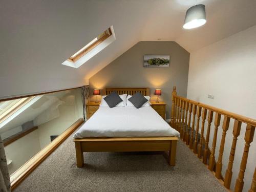 恩布尔顿恩布尔顿Spa酒店&公寓的一间卧室设有一张床和一个楼梯