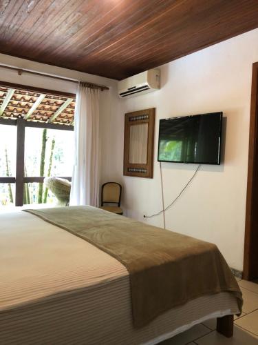 安格拉杜斯雷斯Sítio Bagatelle com cachoeira e piscina!的卧室配有一张床和壁挂式平面电视。