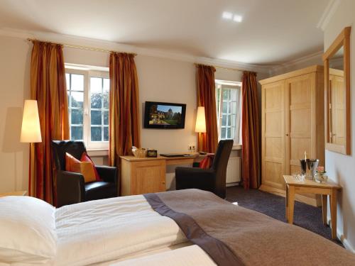 马林费尔德克劳斯特普弗特皇宫酒店的酒店客房,配有一张床、一张桌子和椅子
