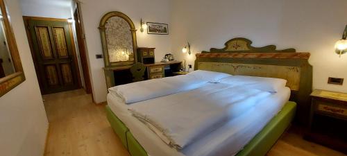 卡纳泽伊格尼斯特拉阿尔皮纳酒店的一间卧室配有一张大床和木制床头板