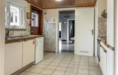 MerkemCozy Home In Merkem With Wifi的厨房配有白色橱柜和瓷砖地板。