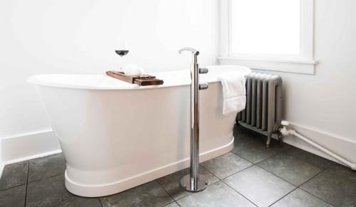 柯林斯堡The Armstrong Hotel的浴室设有白色浴缸,配有散热器