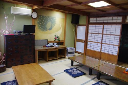高山高山日式旅馆的一间设有两张桌子和一张书桌的房间