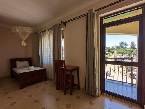波特尔堡Kasenene Legacy Hotel的客房设有床、窗户和桌子。