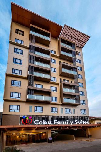 宿务Cebu Family Suites powered by Cocotel的一座高大的公寓楼,上面有标志