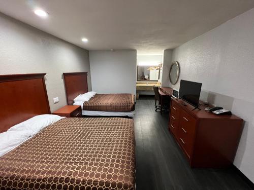 琼斯伯勒Scottish inns Jonesboro的酒店客房配有两张床和一张书桌