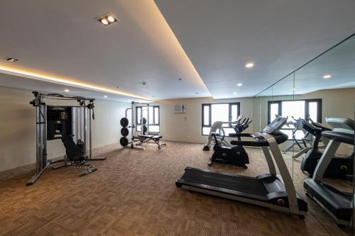 宿务Cebu Family Suites powered by Cocotel的健身房,配有跑步机和有氧运动器材