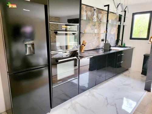 诺伊斯·勒·格兰德chambres privées dans maison bord de marne proche Disney et Paris的厨房配有不锈钢冰箱和大理石地板。