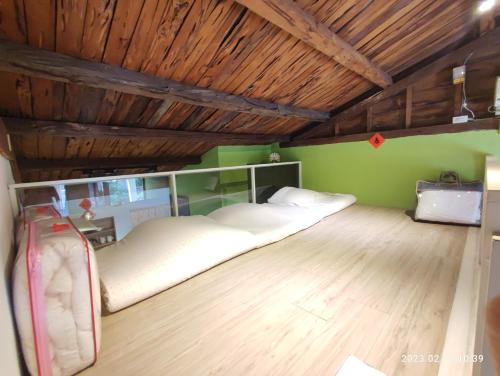 花莲市陋室铭的配有绿色墙壁和木制天花板的客房内的两张床
