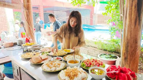 宁平Văn Lâm Villa的站在食物自助餐前的妇女