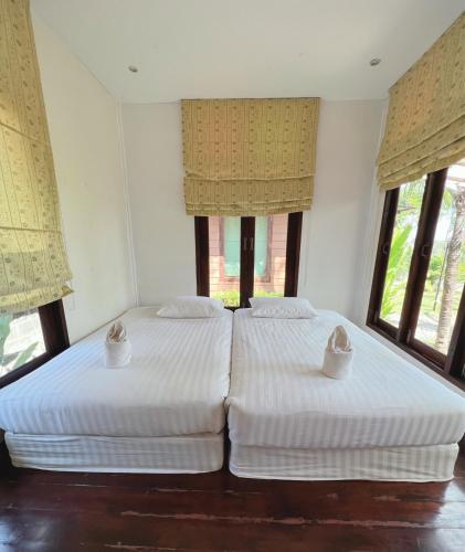 南府เฮือนริมน่าน Huen Rim Nan的带2扇窗户的客房内的2张床
