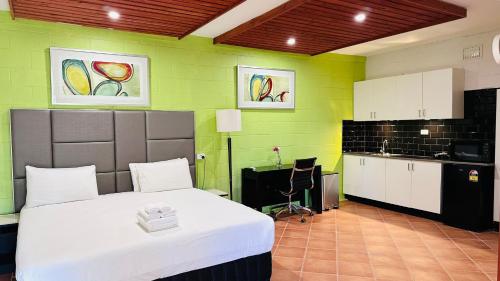 戈斯福德戈斯福德汽车旅馆的一间卧室配有床,厨房拥有绿色的墙壁