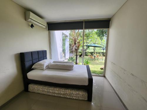 岩望Jagad House的一间卧室设有一张床和一个大窗户