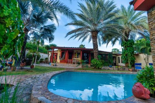 ParaguachiVilla Cococaribic Isla Margarita Venezuela的棕榈树屋前的游泳池