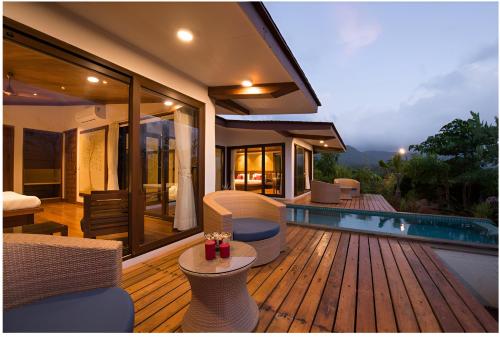 罗纳瓦拉Resort Amanzi的一个带椅子的木制甲板和游泳池