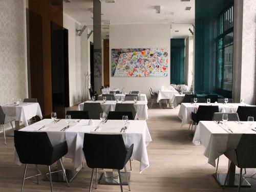 莱维采Hotel Lev的一间设有白色桌椅的用餐室