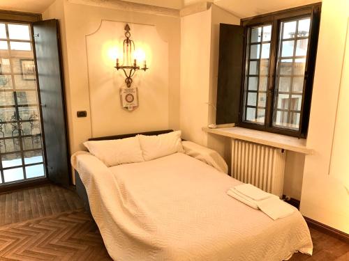 圣马力诺Borgoloto Suite 17的配有2扇窗户的客房内的1张床