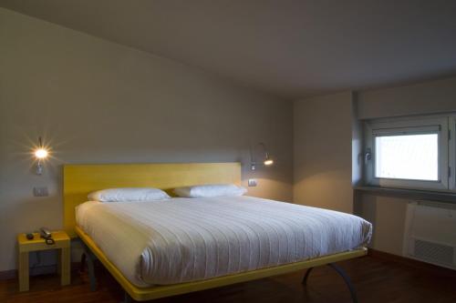 卡迈格拉特罗希拉诺圣洛伦索斯艾柏佳酒店的卧室配有一张带白色床单的大床和窗户。