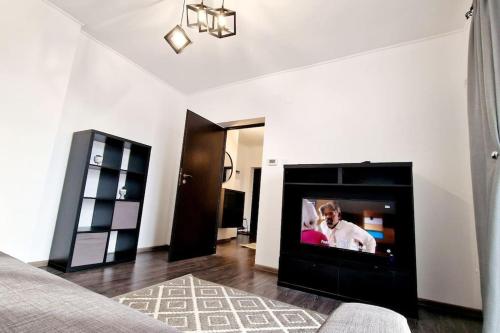 皮特什蒂Belle Apartments - Republicii的客厅设有壁炉,配有平面电视。