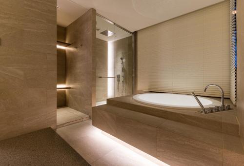 东京THE skM TOKYO HOTEL & DINING的一间带大浴缸和淋浴的浴室
