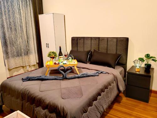 吉隆坡Petalz Luxury Suite 10Pax MID VALLEY OLD KLANG ROAD OUG KLANG LAMA KL的一间卧室配有一张桌子和一张床铺