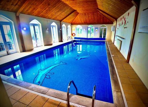 昂姆林Angmering Manor Hotel的大楼内一个蓝色的大型游泳池