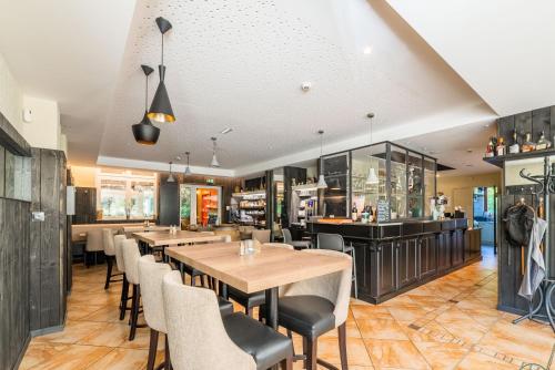 坦恩Hotel Restaurant au Floridor的一间带桌椅的餐厅和一间酒吧