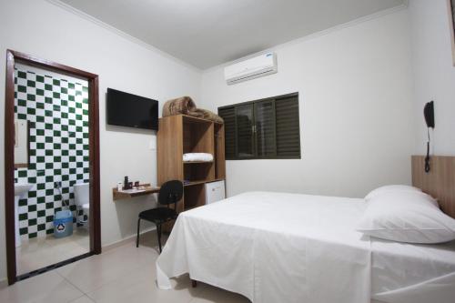 奥林匹亚奥林匹亚埃斯梅拉达旅馆的一间卧室配有一张床、一张书桌和一个窗户。