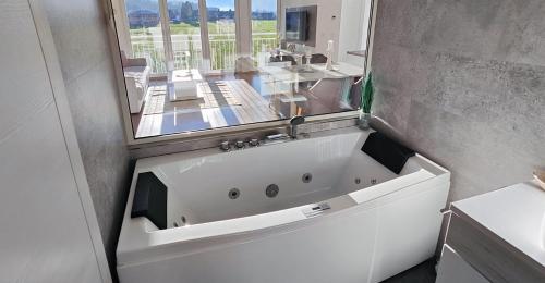埃本塞Unterschlupf的浴室设有白色浴缸及镜子