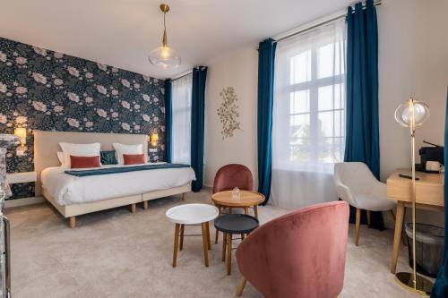 索姆河畔的圣瓦列里Hôtel Échappée en Baie - Parking privé gratuit dont forfaits bornes électriques réservable的卧室配有一张床和一张桌子及椅子
