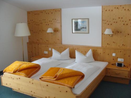 因斯布鲁克斯切福勒酒店的一间卧室配有一张带两个枕头的木床