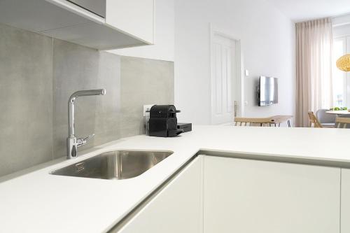 奇克拉纳－德拉弗龙特拉CASA DE LA VEGA SUITES的白色厨房内带水槽的厨房