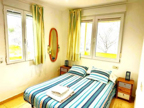 马德里瓦勒拉公寓的一间卧室配有带2个枕头的床和2个窗户。