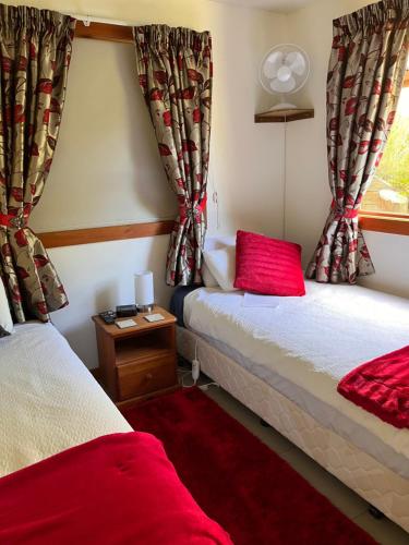 泰晤士Waiotahi Valley Lodge的客房设有两张床和窗户。