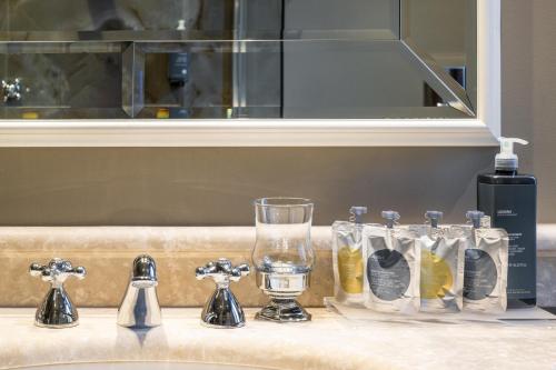 威尼斯帕拉佐普瑞里酒店的一个带水槽的柜台,配有玻璃杯和一瓶水