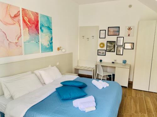 陶尔米纳Bed and Breakfast Arco dei cappuccini的一间卧室配有蓝色的床和毛巾