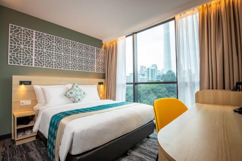 吉隆坡Santa Grand Signature Kuala Lumpur的配有一张床、一张书桌和一扇窗户的酒店客房