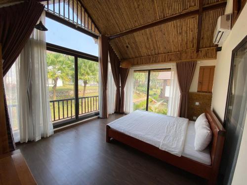 巴位Thang Mây Village Rersort的一间卧室设有一张床和一个大窗户